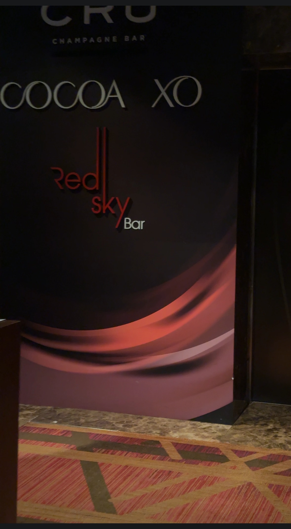 「Red Sky Bar」のロゴサインと「CRU CHAMPAGNE BAR」の壁面案内