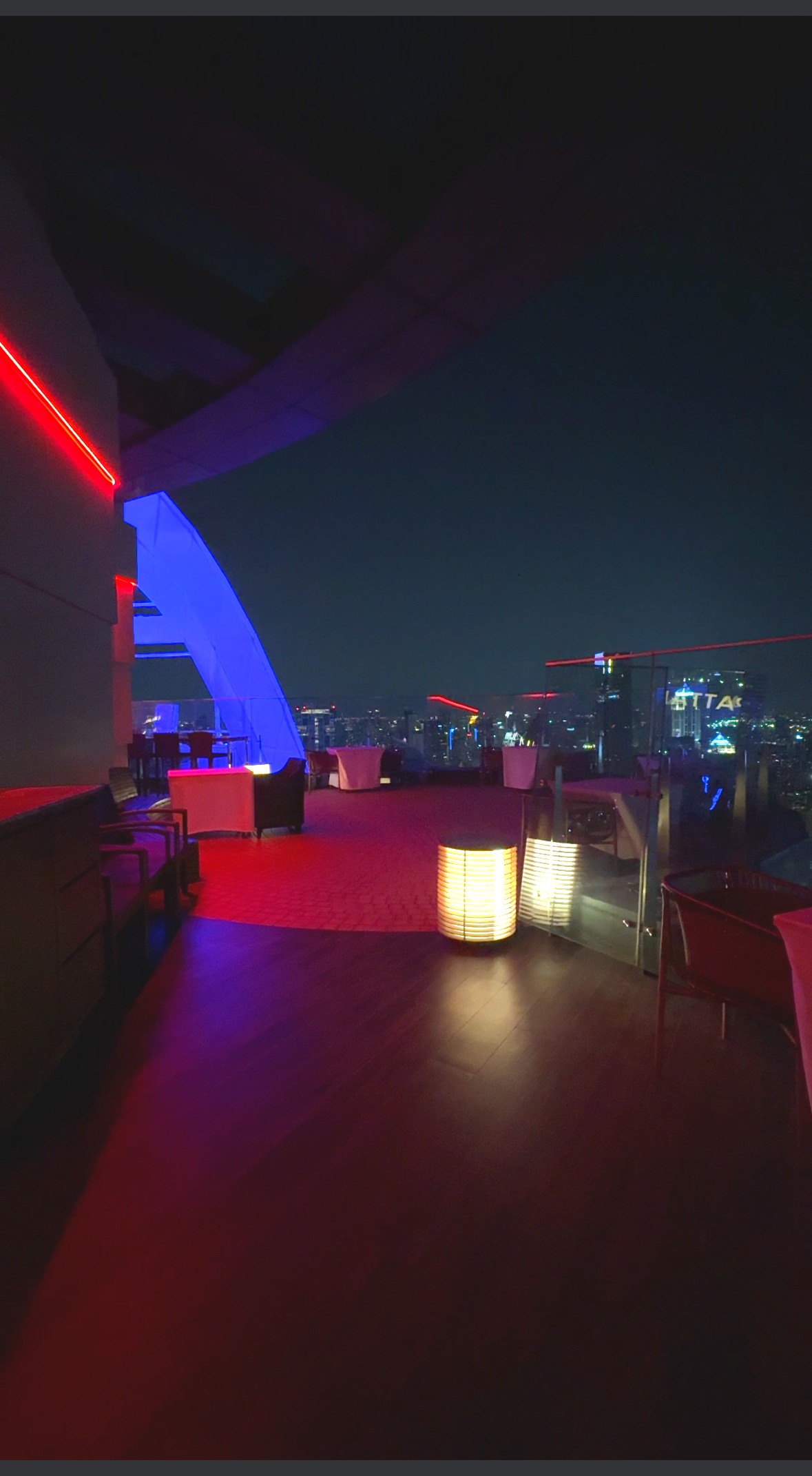 屋外テラス席から見るバンコクの夜景と青・赤のライトアップ